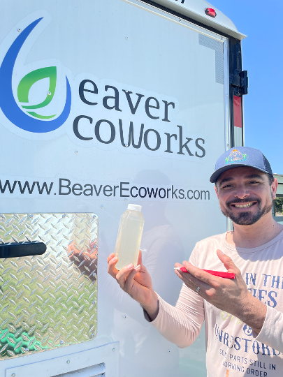 Beaver EcoWorks engineer holding a treated-water sample at the CF15 trailer