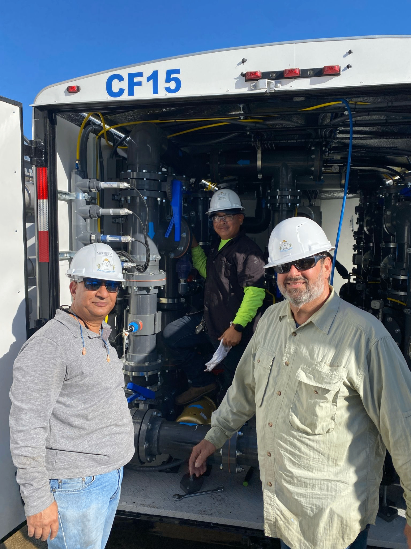 Beaver EcoWorks engineers in front of the CF15 treatment trailer on a customer site